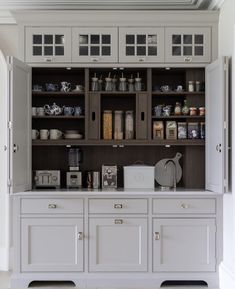 a kitchen with white cabinets and lots of drawers on the back wall in front of it