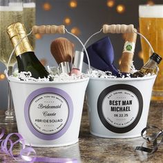 two buckets filled with different types of personal care items and wine glasses on a table