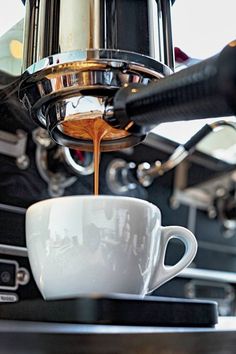 coffee being poured into a white cup