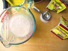 ingredients to make an ice cream dessert on a wooden table with measuring cups and spoons