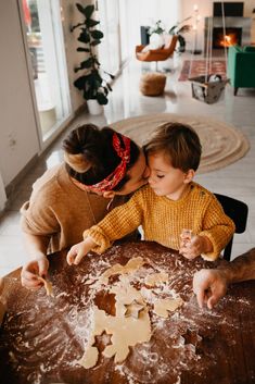 a woman and child making cookies on a table