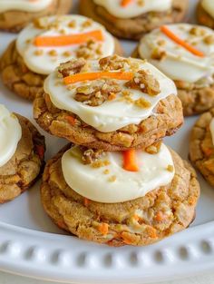 carrot cookies with cream cheese frosting and candies on top are arranged on a white plate