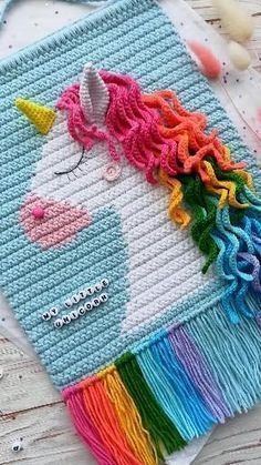 a crocheted unicorn is on the table with beads and scissors next to it