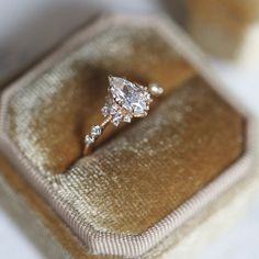 an engagement ring sits in a velvet box