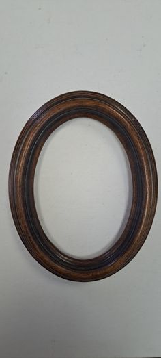 an oval wooden frame on a white background with space for the word'o'in it