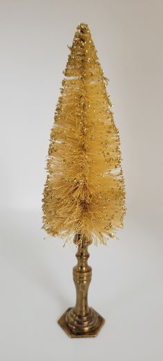 a small gold tinsel christmas tree on a stand