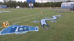 an empty football field painted with blue and white letters that spell out the word toru