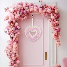 a pink door decorated with flowers and a heart