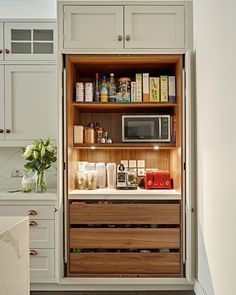 an open cabinet in the middle of a kitchen filled with lots of food and condiments