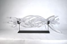 a sculpture made out of glass sitting on top of a metal stand