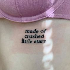 a woman's stomach with the words made of crushed little stars tattooed on it