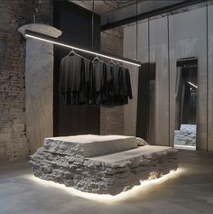 a room with some clothes hanging on the wall and lights in front of it that are lit up