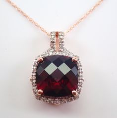 "Rose Gold Garnet and Diamond Halo Pendant Necklace 18\" Chain.  Diamond Specifications: Shape: Round  Amount: 32 Diamonds Color: H (colorless) Clarity: I1 (eye clean) Carat Weight: .15 carat Gemstone Specifications: Type: Mozambique Garnet Shape: Cushion Cut Checkerboard Color: Brown Measurement: 10 X 10 mm  Carat Weight: 4 carats Metal Specifications: Type: 10K Rose Gold Weight: 3.3 grams  Chain: 18\" 10K Rose Gold Chain Pendant Measurement: 18 X 13 mm  Additional Information: Gift Box Include Cushion Cut Diamond Accent Necklace For Wedding, Round Wedding Necklaces With Accent Stones, Rose Gold Necklace With Gemstone Accents For Formal Occasions, Fine Jewelry Wedding Necklaces With Accent Stones, Formal Rose Gold Necklace With Gemstone Accents, Elegant Wedding Necklace With Accent Stones, Elegant Wedding Necklaces With Accent Stones, Elegant Necklaces With Accent Stones For Wedding, Wedding Cubic Zirconia Necklace With Accent Stones