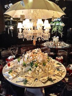 a dining room table with an umbrella over it and several place settings on the table