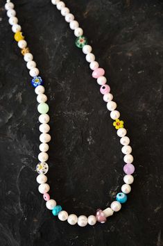 Revive the child in you with this playful and colorful Mother of Pearl charm necklace with assorted fun and colorful kidult beads. This necklace is a beautiful mix of classic elegance and youthful energy. The white Mother of Pearl beads give a timeless touch, while the kidult beads add a pop of color and playfulness. Mother of Pearl is a gemstone that is said to promote inner peace and emotional balance. The kidult beads add a touch of whimsy and fun, making this necklace a perfect accessory for Pearl Charm Necklace, Fun Girl, Emotional Balance, Mala Necklace, Pearl Charms, Classic Elegance, Inner Peace, Crystals And Gemstones, Pearl Beads