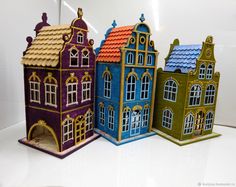 three different colored houses are shown on a white surface