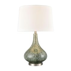 a green lamp with a white shade on it's side and a silver base