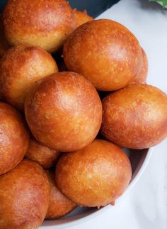 a bowl filled with lots of doughnuts on top of a white countertop