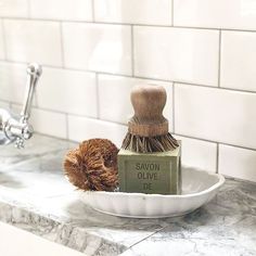 a bathroom sink with a soap dish and brush on the counter top next to it