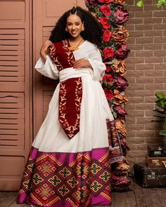 This stunning dress is a true masterpiece of Ethiopian textile art. The main fabric of the dress is made from Menen, a high-quality Ethiopian cotton known for its softness, durability, and lustrous sheen. The Menen fabric adds a touch of luxury to the dress, making it perfect for special occasions. The lower part of the dress is fully handwoven from menen, a fabric known for its intricate patterns and rich texture. The shimmering material adds a touch of elegance and movement to the dress, makin Ethiopian Wedding Dress, Habesha Wedding, Eritrean Dress, Ethiopian Wedding, Ethiopian Clothing, Habesha Dress, Ethiopian Traditional Dress, Ethiopian Women, Ethiopian Dress