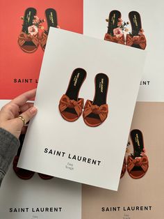 the saint laurent shoes are being held up in front of several different colored cards and envelopes