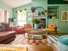 a living room filled with lots of furniture and colorful pillows on top of it's couches