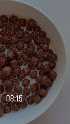 a white bowl filled with chocolate balls on top of a table next to a measuring tape