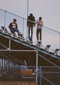 three skateboarders are standing on top of the stairs