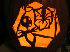 a carved pumpkin with an image of a spider on it