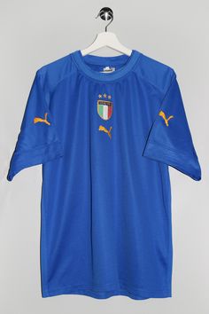 "Puma Italy T-shirt - Size tag: Please always check measurements before buying. Men's XL - Measurements (laying flat): Pit to Pit: 22\" Length: 28.5\" Pit to cuff: 7\" -Wear: /Please see images for details/ Good used condition. Couple of small fabric pulls front and back as shown on the pictures. - Fabric: Polyester *All of our items are preloved pieces so some signs of natural wear and age are to be expected. Please look through the photos carefully to check if the condition is to your satisfaction. *All efforts are made to show any defects however small imperfections may be missed. *We try to describe the sizes as accurately as possible, but please keep in mind that sizes nowadays can differ to sizes used back then. Please note the measurements in the description for the exact size. -Del Blue Short Sleeve Sports Jersey, Blue Short Sleeve Jersey For Sports, Fan Merchandise Short Sleeve Jersey, Blue Crew Neck T-shirt For Sports Season, Blue Cotton Short Sleeve Jersey, Team Logo Jersey Tops With Short Sleeves, Jersey Tops With Team Logo And Short Sleeves, Blue Jersey T-shirt Sportswear, Blue Jersey T-shirt For Sportswear