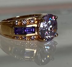 Beautiful rose gold over silver 925 ring with large rounded lilac faceted prong set CZ surrounded by darker purple CZ's on the band and smaller round lilac purple CZ's.   Excellent condition. Ring is stamped 925 CZ  7 and designer mark possibly Ross-Simons. Ring is a size 7 on US scale. 925 Ring, Lilac Purple, Beautiful Rose, 925 Silver Rings, Cocktail Ring, Cocktail Rings, Beautiful Roses, Dark Purple, Rings Statement