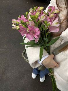 a woman holding a bouquet of pink flowers