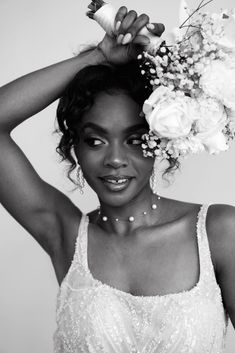 a black and white photo of a woman with flowers in her hair