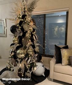 a christmas tree decorated with black and white ornaments in a living room next to a couch