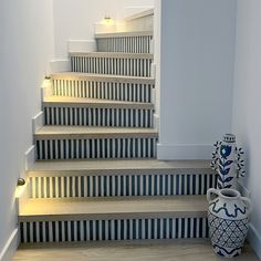 a blue and white vase sitting on top of a set of stairs next to a stair case