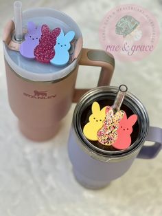 a cup with some bunny shaped magnets on it next to a mug filled with sprinkles