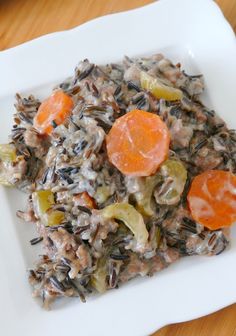 a white plate topped with wild rice and carrots