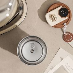 an alarm clock sitting on top of a table next to a cup and saucer