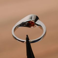 It is a natural red garnet ring. The main stone is 7mm*7mm round cut, weight about 1.67 carats. The basic metal is sterling silver and plated with rhodium. To change the metal to a solid gold (white/rose) or platinum is also available, please ask for a quotation if you want. You can also go to my shop Home for more elegant rings: https://www.etsy.com/shop/godjewelry?ref=hdr_shop_menu Garnet is the birthstone of January. More garnet rings: https://www.etsy.com/shop/godjewelry?ref=hdr_shop_menu&am Garnet Birthstone Ring In White Gold For Promise, White Gold Garnet Birthstone Promise Ring, Silver Garnet Birthstone Ring For Promise, Silver Garnet Solitaire Ring, Silver Garnet Ring With Prong Setting, Silver Garnet Birthstone Ring For Anniversary, Garnet Rings In Fine Jewelry Style, Silver Garnet Jewelry With Prong Setting, Fine Jewelry Garnet Rings With Polished Finish