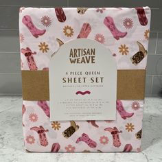 a pink and brown sheet set with cowboy boots on the front, sitting on top of a counter