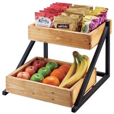 two wooden trays filled with fruits and vegetables on top of each other, next to bags of chips