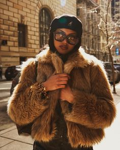 a woman wearing glasses and a fur coat