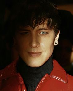 a close up of a person wearing a red jacket