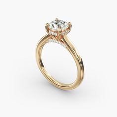 a yellow gold engagement ring with an oval cut diamond on the center and side stones