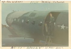 an old photo of a man standing in the doorway of a plane