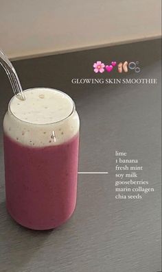 a pink smoothie in a glass with a spoon