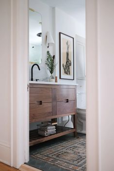 an open door leading to a bathroom with a sink and mirror on the wall above it