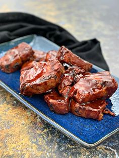 a blue plate topped with meat covered in bbq pork ribs