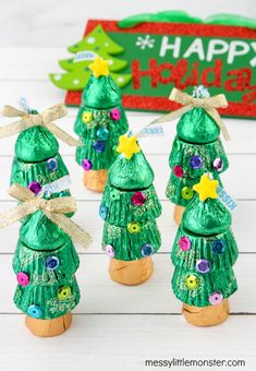 three green christmas trees made out of candy wrappers with the words happy holidays written on them