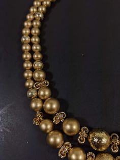 This vintage necklace has 2 strands of gold tone beads. It measures 18 inches long with a hook style clasp. It has only very light wear. R Gold Long Single Strand Necklace, Gold Pearl Costume Jewelry Necklace, Multi-strand Gold Jewelry For Celebration, Gold Single Strand Round Bead Necklaces, Gold Single Strand Round Bead Necklace, Gold Single Strand Beaded Necklace With Round Beads, Gold Double Strand Jewelry For Festive Occasions, Gold Single Strand Beaded Necklace, Gold Necklace With Beaded Chain For Party